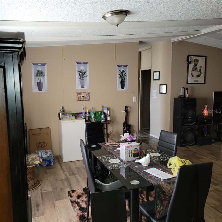 A dining area features a glass-top table, black chairs, and a small bar cabinet — 16165 NARROW STREET, BROOKSVILLE, FL