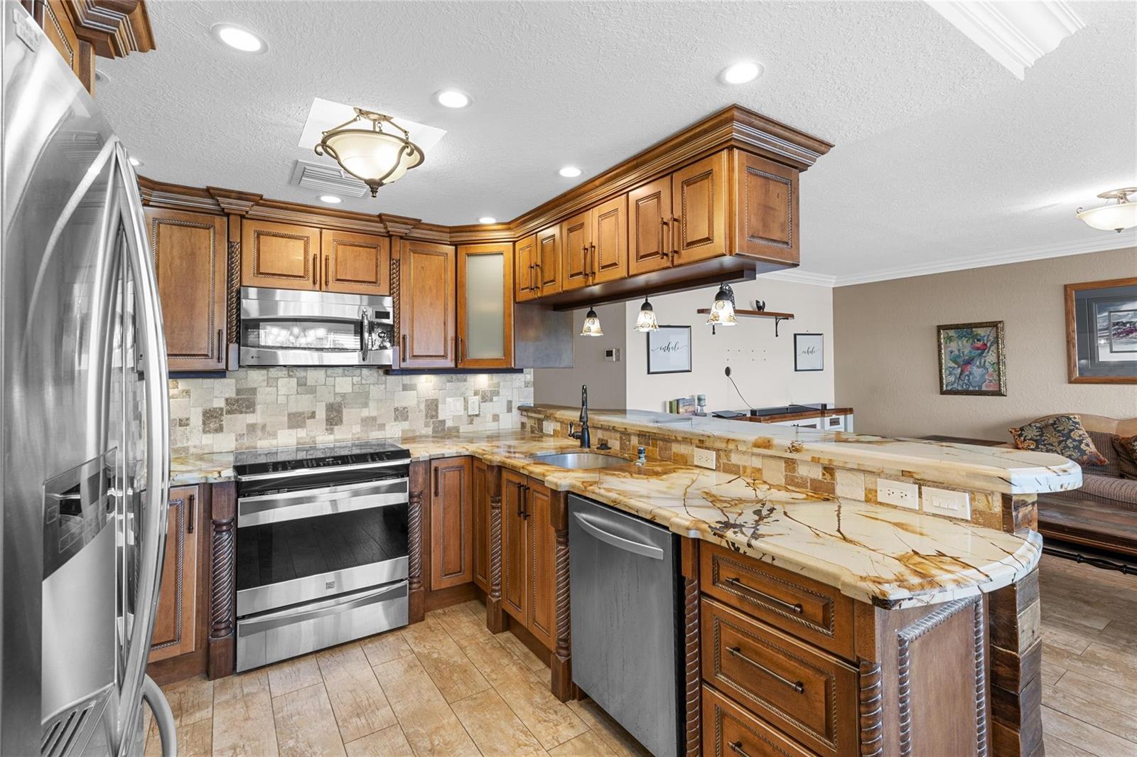 A kitchen features wood cabinets, granite countertops, stainless steel appliances, and a tiled backsplash — 417 Richmond C # 417, Deerfield Beach FL 33442, DEERFIELD BEACH, FL