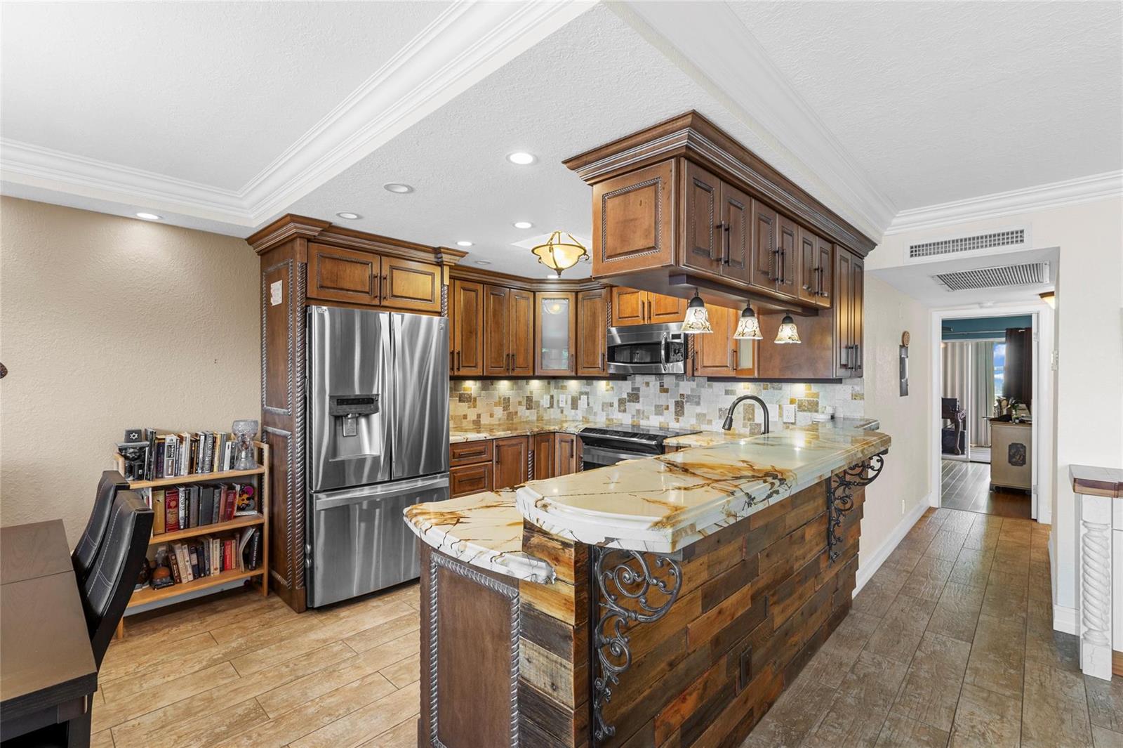 A kitchen features dark wood cabinets, a rustic wood-paneled island, and a stone countertop — 417 Richmond C # 417, Deerfield Beach FL 33442, DEERFIELD BEACH, FL