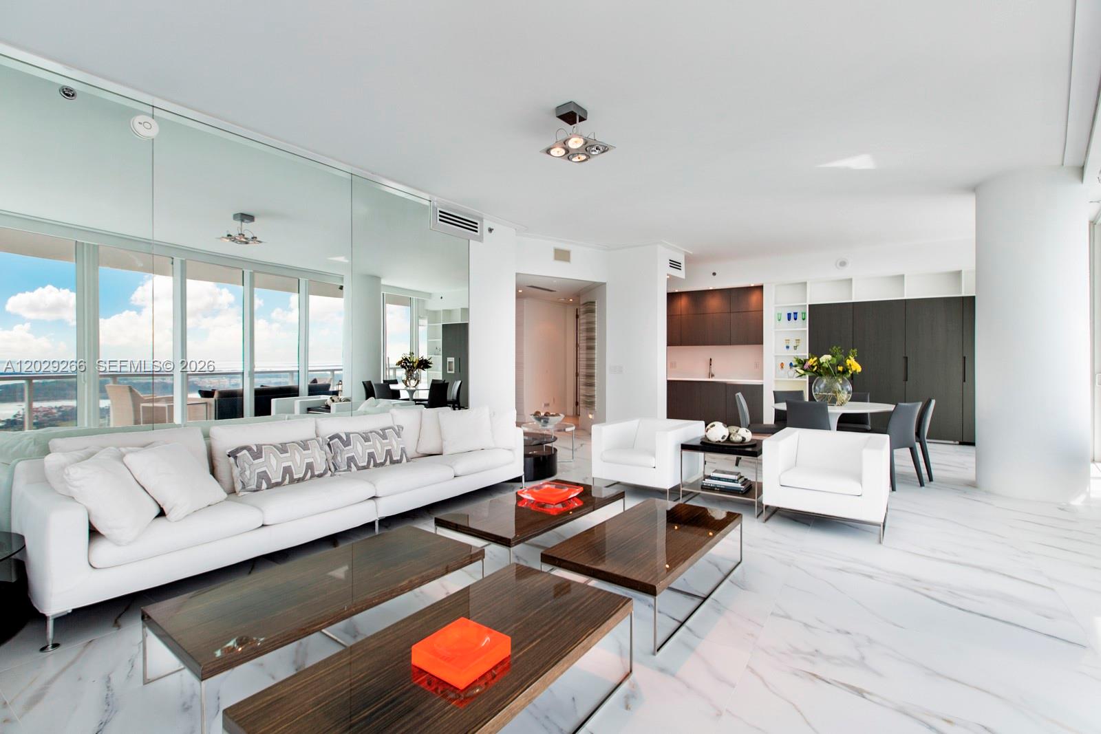 A modern living room features white sofas, dark wood coffee tables, and marble flooring — 100 S Pointe Dr # 3701, Miami Beach FL 33139, MIAMI BEACH, FL