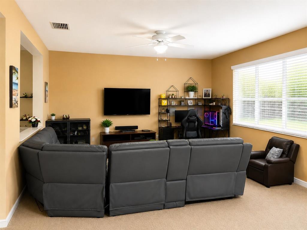 A living room features a gray sectional sofa, a wall-mounted television, and a computer desk — 2809 SHELBURNE WAY, ST CLOUD, FL