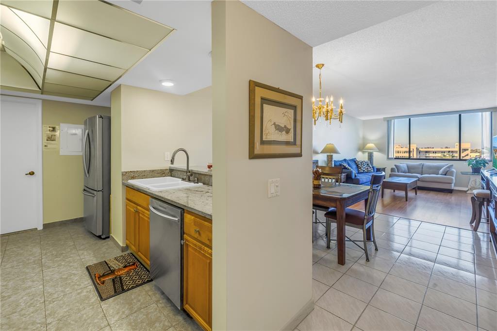 A kitchen with granite countertops and stainless steel appliances opens into a dining and living area — 6287 BAHIA DEL MAR CIRCLE UNIT 603, ST PETERSBURG, FL