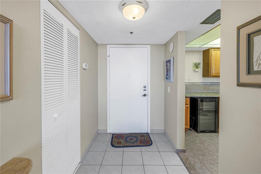 An entryway features white tile flooring, a louvered closet door, and a white front door — 6287 BAHIA DEL MAR CIRCLE UNIT 603, ST PETERSBURG, FL