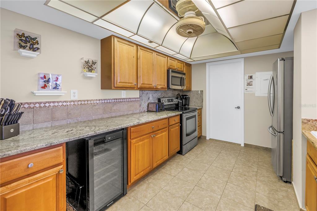 A kitchen features wood cabinets, granite countertops, stainless steel appliances, and a coffered ceiling — 6287 BAHIA DEL MAR CIRCLE UNIT 603, ST PETERSBURG, FL