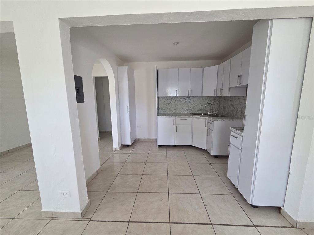 A kitchen with white cabinets, marble-patterned countertops, and light-colored tile flooring — Hato Rey GARDEL #28, SAN JUAN, PR