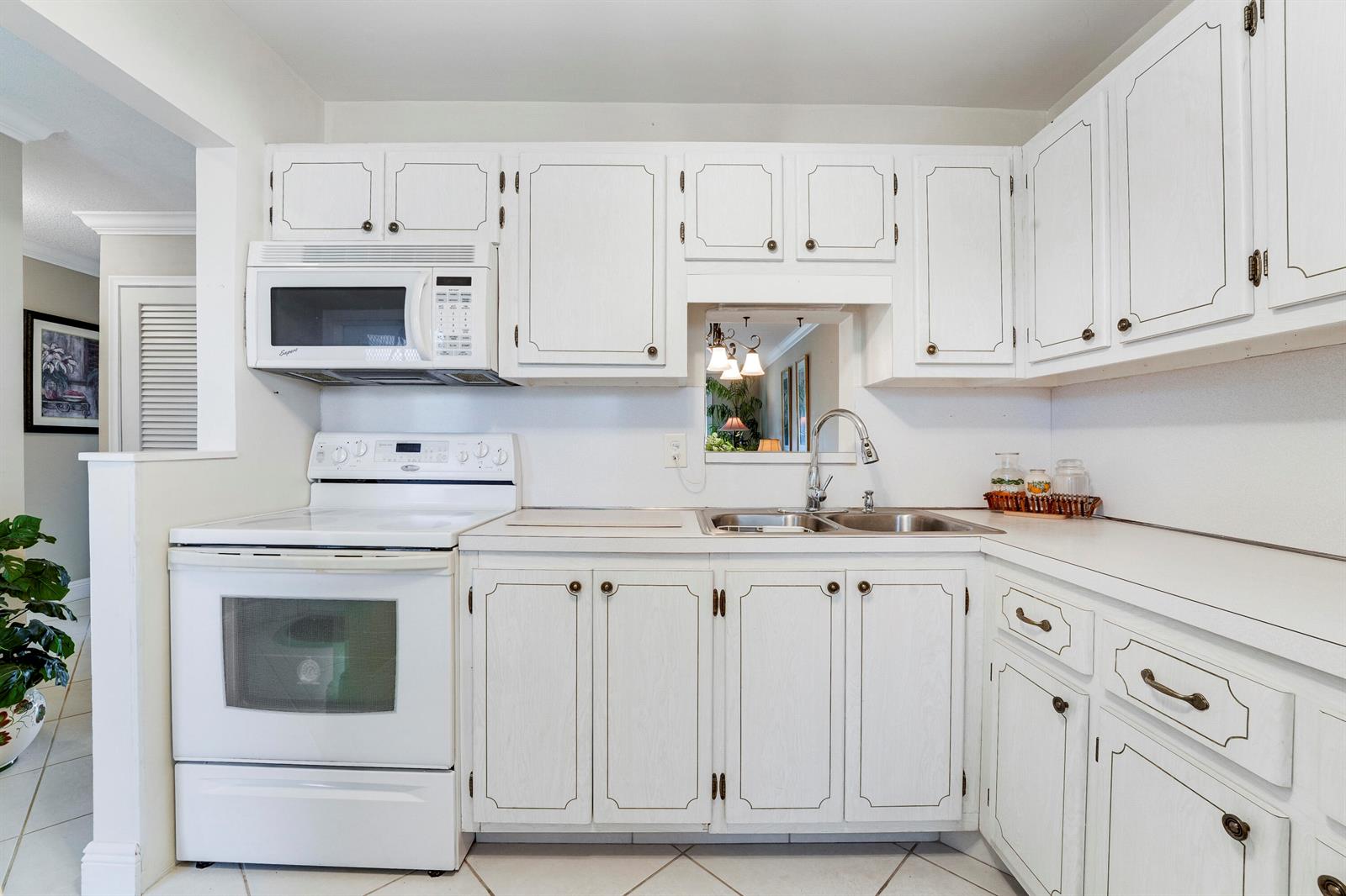 A kitchen featuring white cabinets, white appliances, a double sink, and a pass-through window — 2132 NE 1st Way # 201, Boynton Beach FL 33435, BOYNTON BEACH, FL