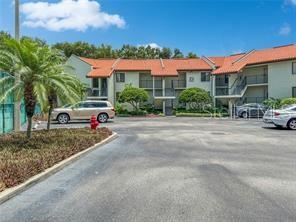 A two-story apartment building with a parking lot and a palm tree in the foreground — 1515 PINELLAS BAYWAY S UNIT 40, ST PETERSBURG, FL