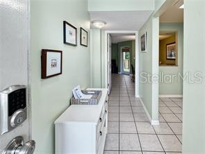 A hallway with light green walls, tiled floors, and a white console table — 1515 PINELLAS BAYWAY S UNIT 40, ST PETERSBURG, FL