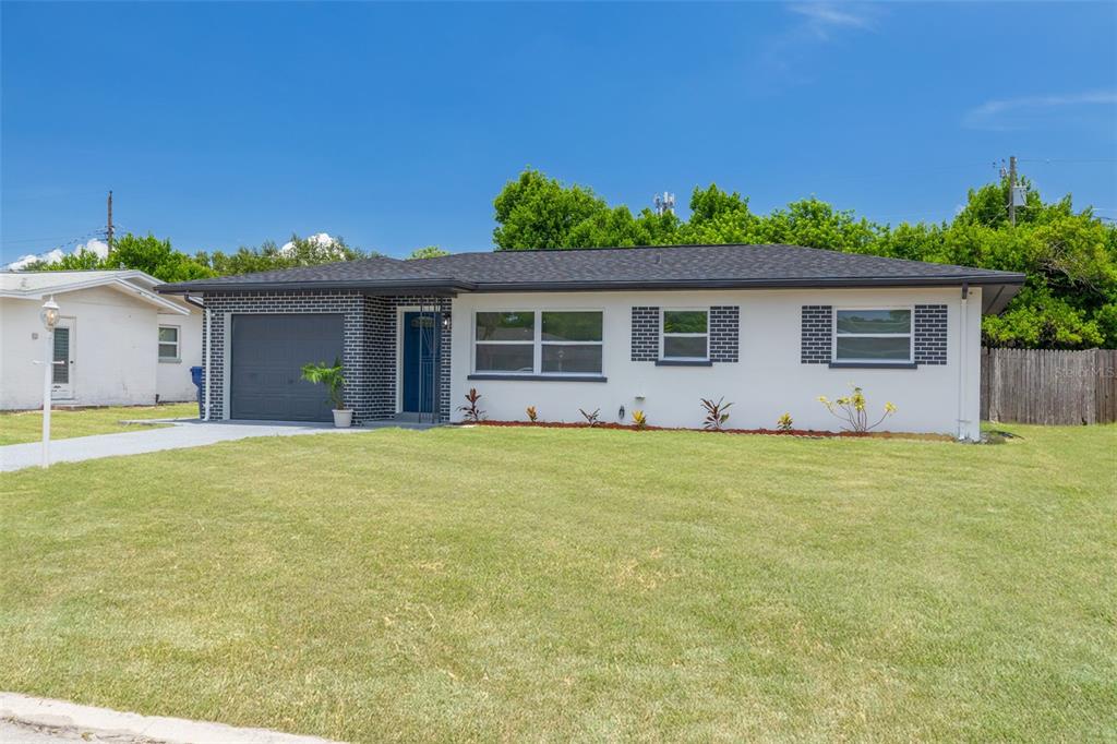 A single-story house with a white exterior, dark brick accents, and a front-facing garage — 11189 108TH WAY, LARGO, FL