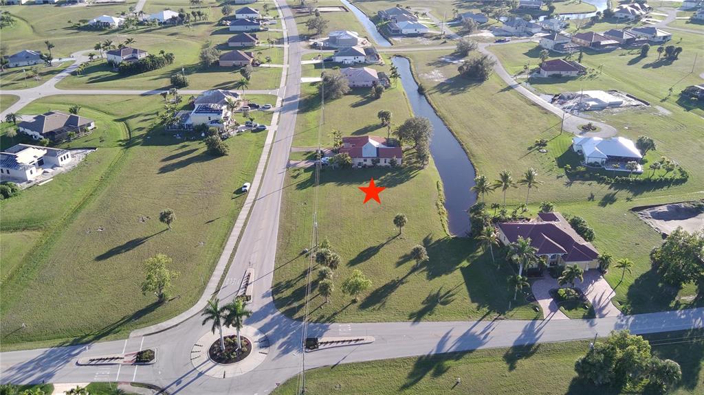 An aerial view shows a residential lot with a red star near a canal — 17245 CAPE HORN BOULEVARD, PUNTA GORDA, FL