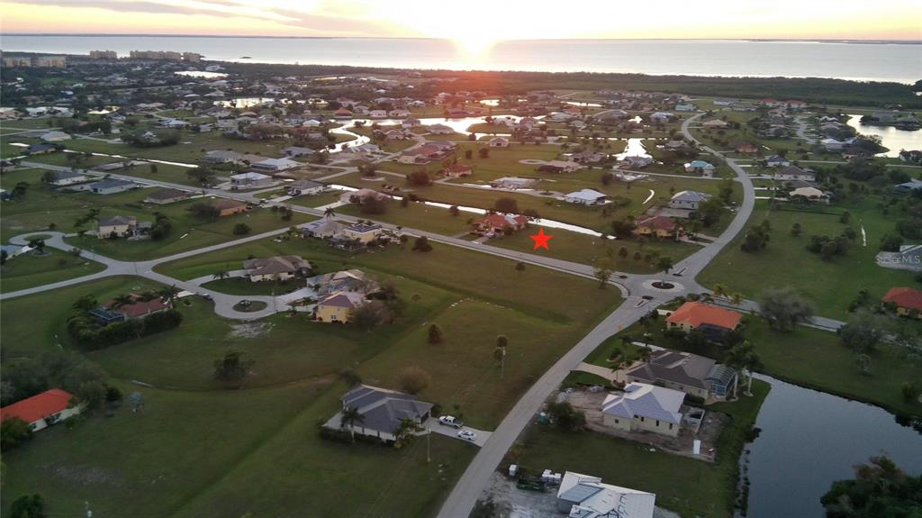An aerial view shows a residential neighborhood with a red star marking a vacant lot — 17245 CAPE HORN BOULEVARD, PUNTA GORDA, FL