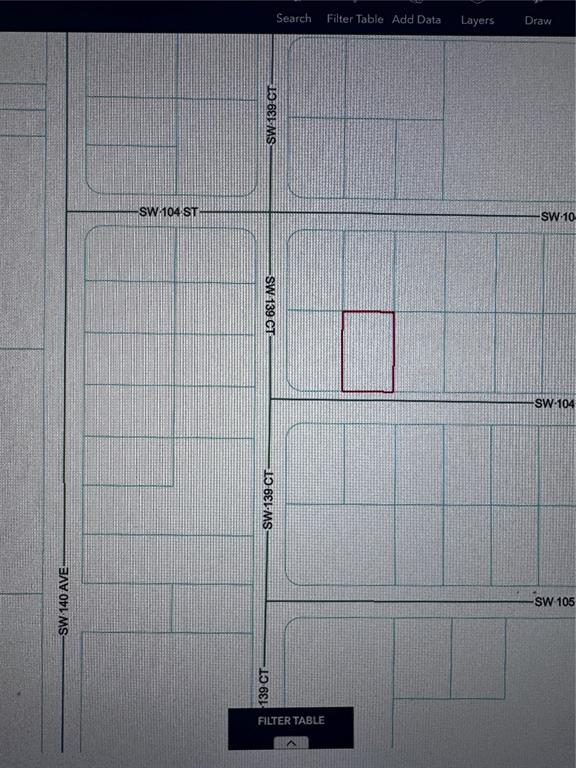This is a digital map showing a highlighted rectangular property lot near a street intersection — 0 SW 104TH LANE, DUNNELLON, FL