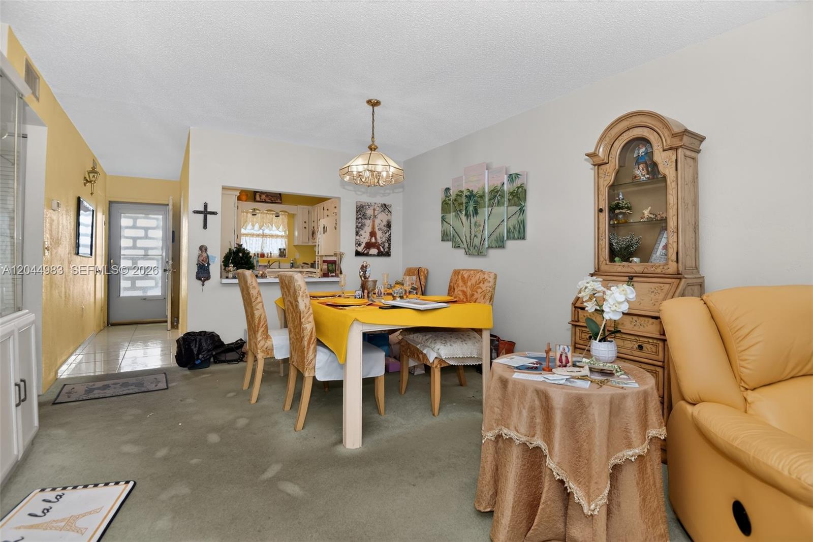 A dining area features a yellow-clothed table, a hutch, and a pass-through to the kitchen — 2711 N HALIFAX AVE # 693, Daytona FL 32118, DAYTONA, FL