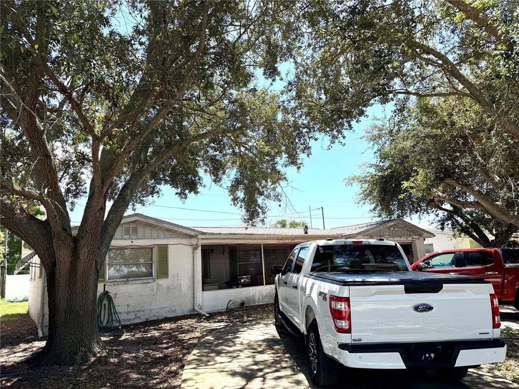 A white pickup truck is parked in the driveway of a single-story house under trees — 5136 MECASLIN DRIVE, NEW PORT RICHEY, FL