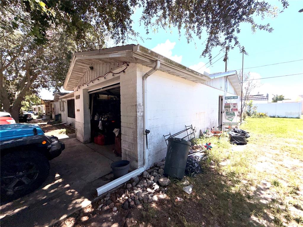 A white concrete block garage with a driveway and a side yard in a residential area — 5136 MECASLIN DRIVE, NEW PORT RICHEY, FL
