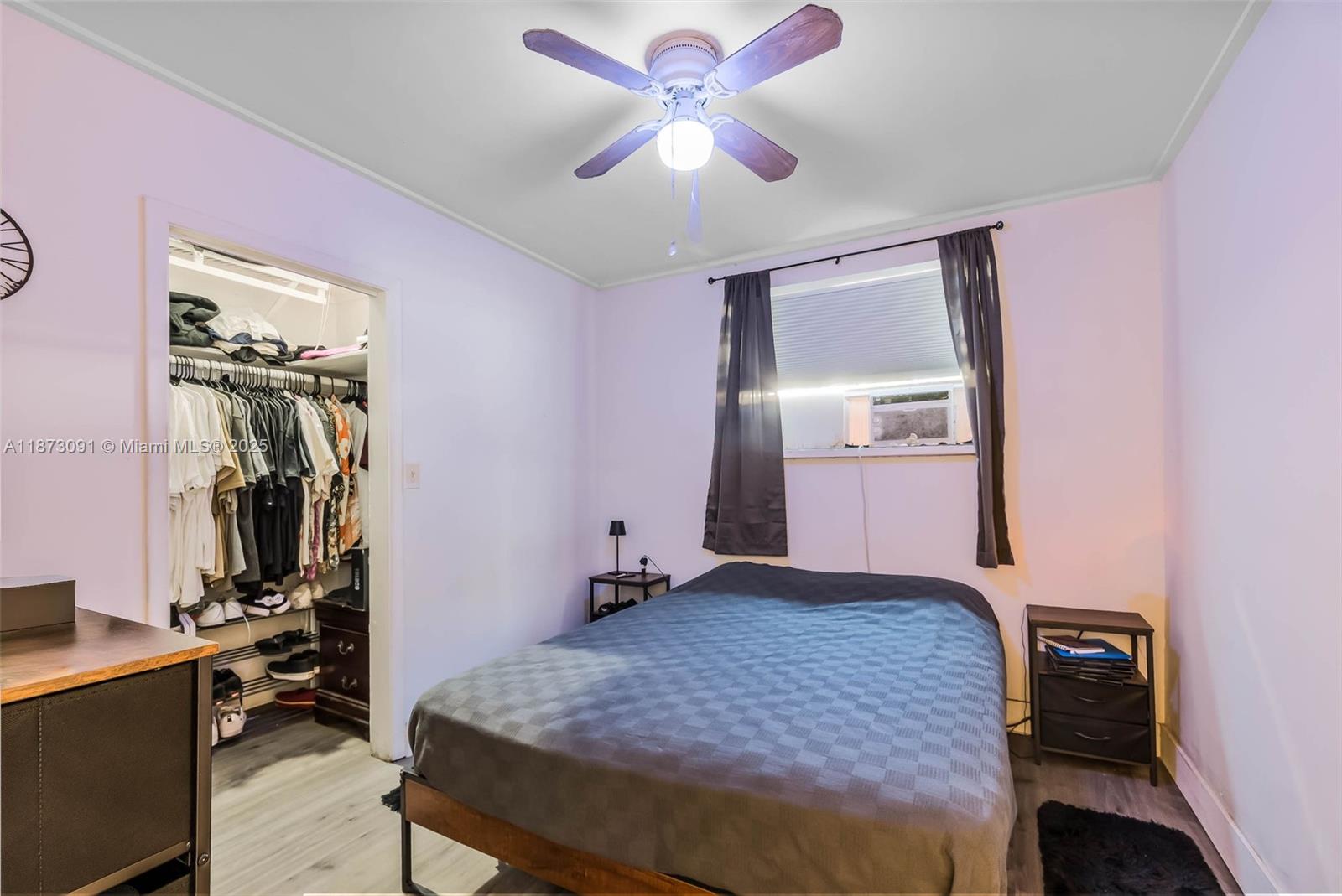 A bedroom features a bed, a ceiling fan, a closet, and light-colored walls — 180 NW 59th St, Miami FL 33127, MIAMI, FL