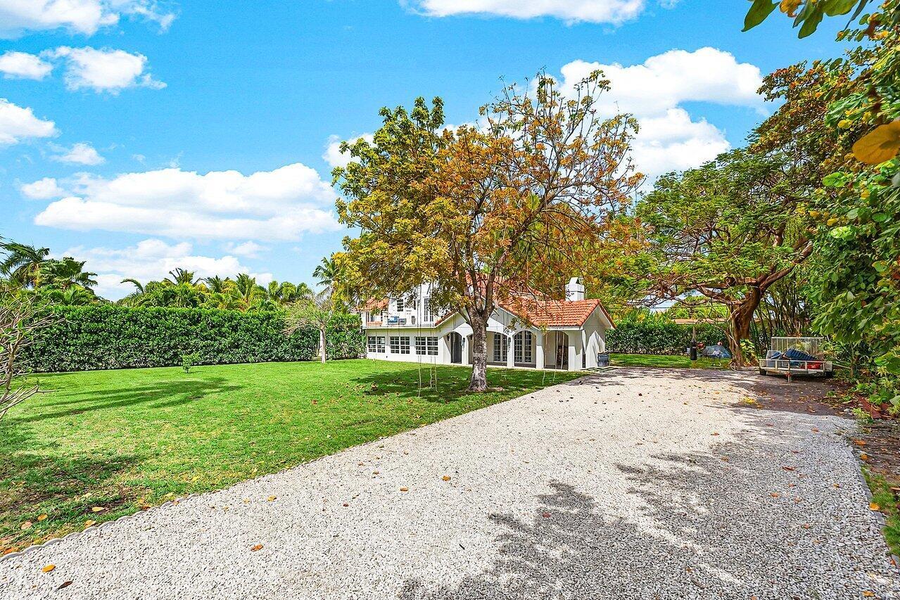 A white house with a red tile roof sits behind a large gravel driveway — 321 SW 1st Avenue, Boynton Beach FL 33435, BOYNTON BEACH, FL