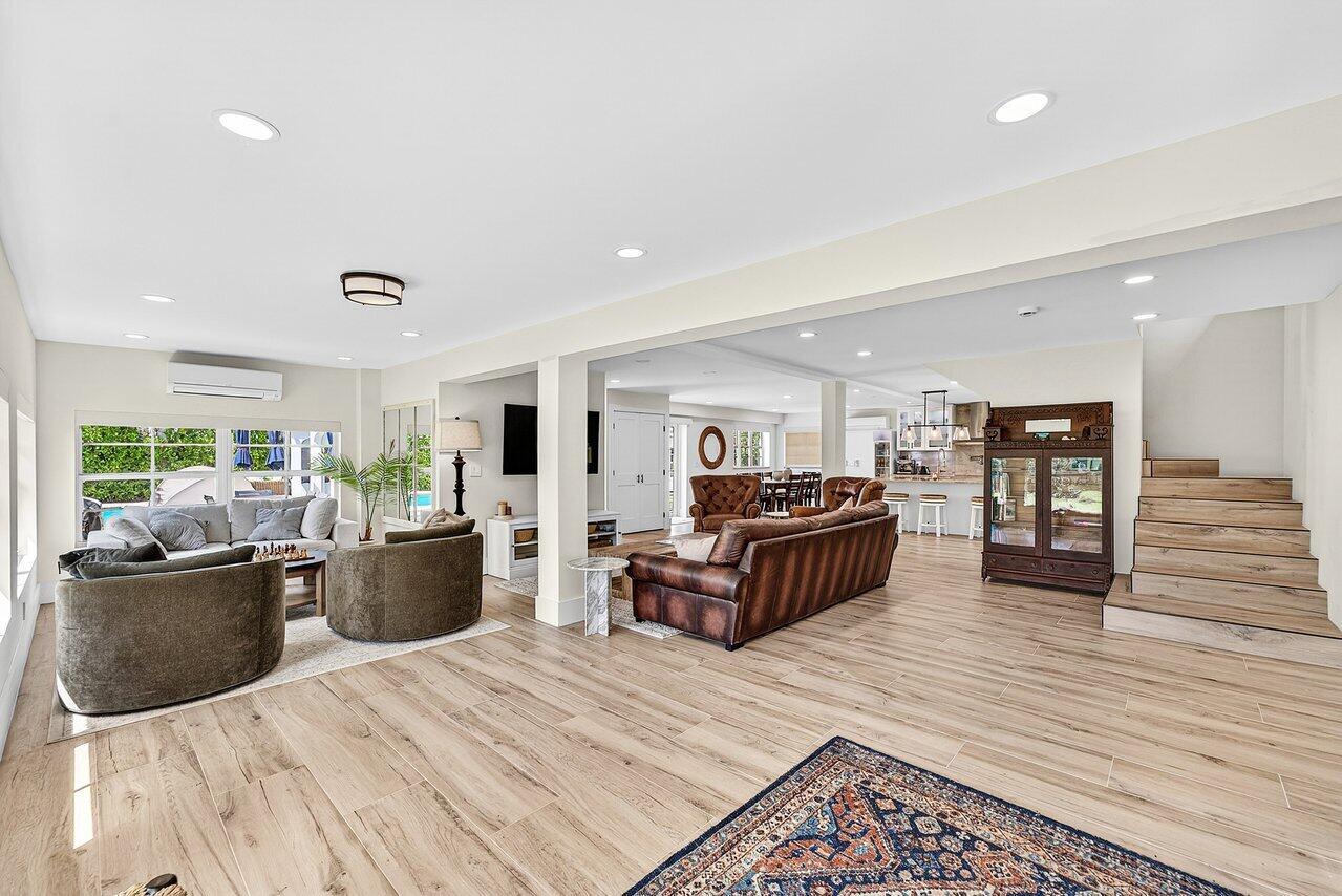 An open-concept living area features light wood-look tile flooring, recessed lighting, and a staircase — 321 SW 1st Avenue, Boynton Beach FL 33435, BOYNTON BEACH, FL
