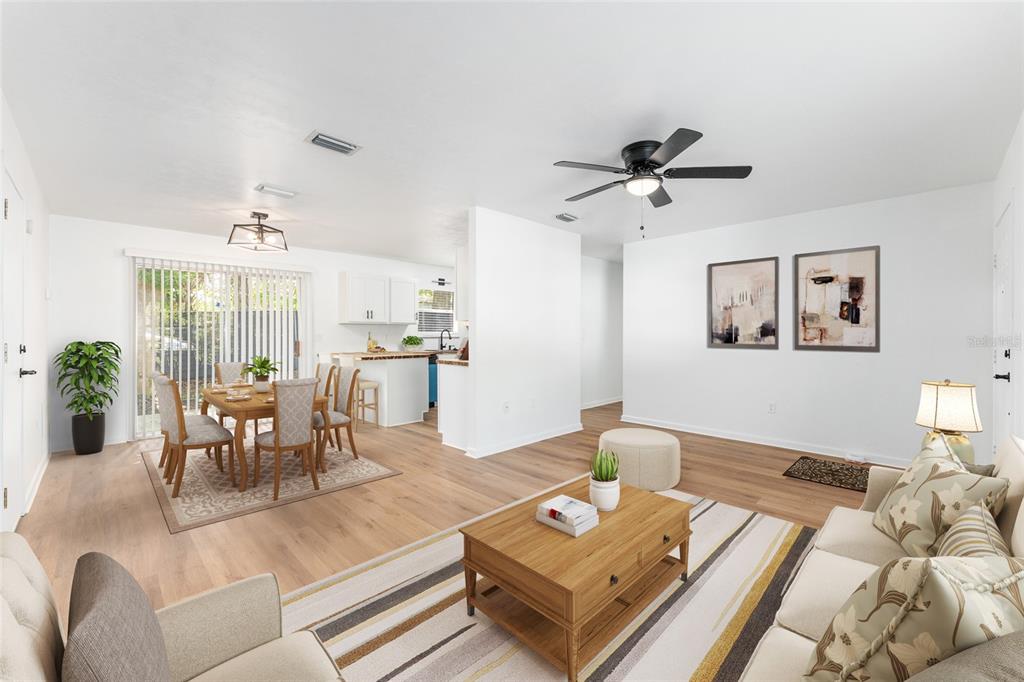 An open-concept living and dining area with light wood floors and a ceiling fan — 5701 SW 47TH PLACE, GAINESVILLE, FL