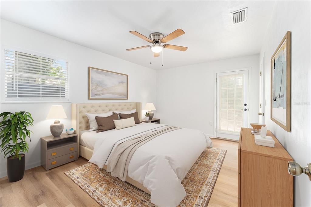 A bedroom features a tufted headboard, a ceiling fan, a dresser, and a glass-paneled door — 5701 SW 47TH PLACE, GAINESVILLE, FL