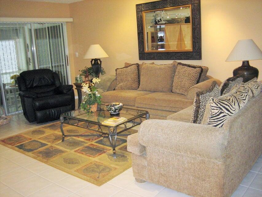 A living room features a beige sofa, a black recliner, and a glass-topped coffee table — 17256 Boca Club Boulevard # 1401, Boca Raton FL 33487, BOCA RATON, FL