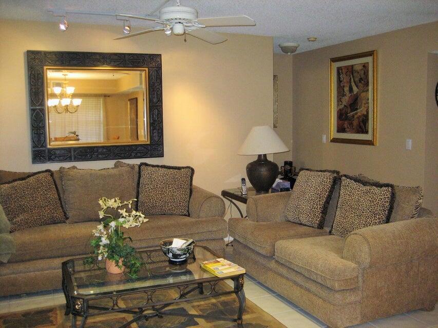 A living room features two tan sofas, a glass coffee table, and a large wall mirror — 17256 Boca Club Boulevard # 1401, Boca Raton FL 33487, BOCA RATON, FL