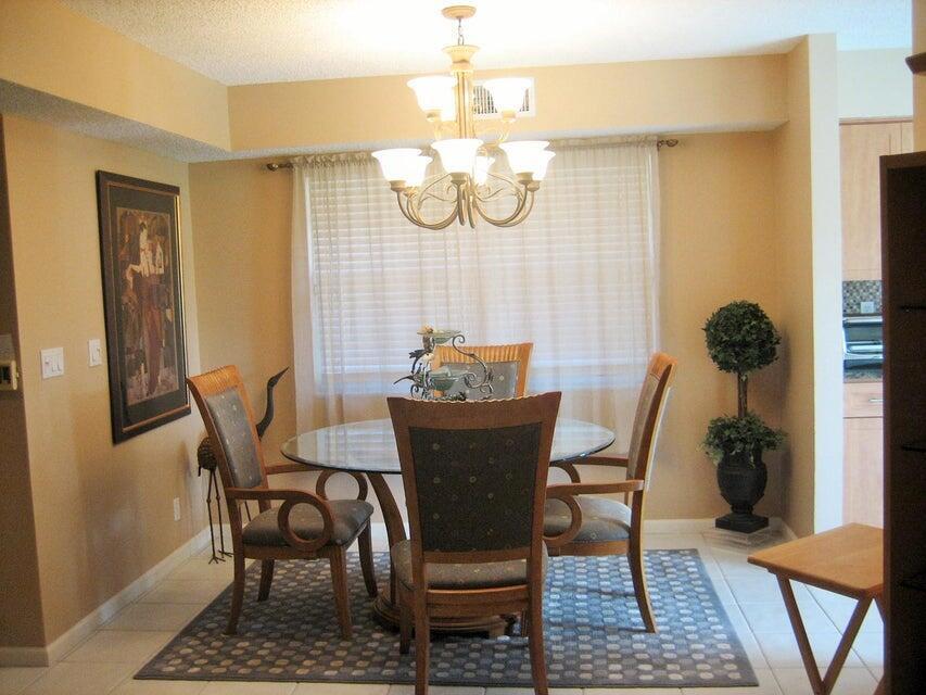 A dining room features a glass-topped table, four chairs, a chandelier, and a patterned rug — 17256 Boca Club Boulevard # 1401, Boca Raton FL 33487, BOCA RATON, FL