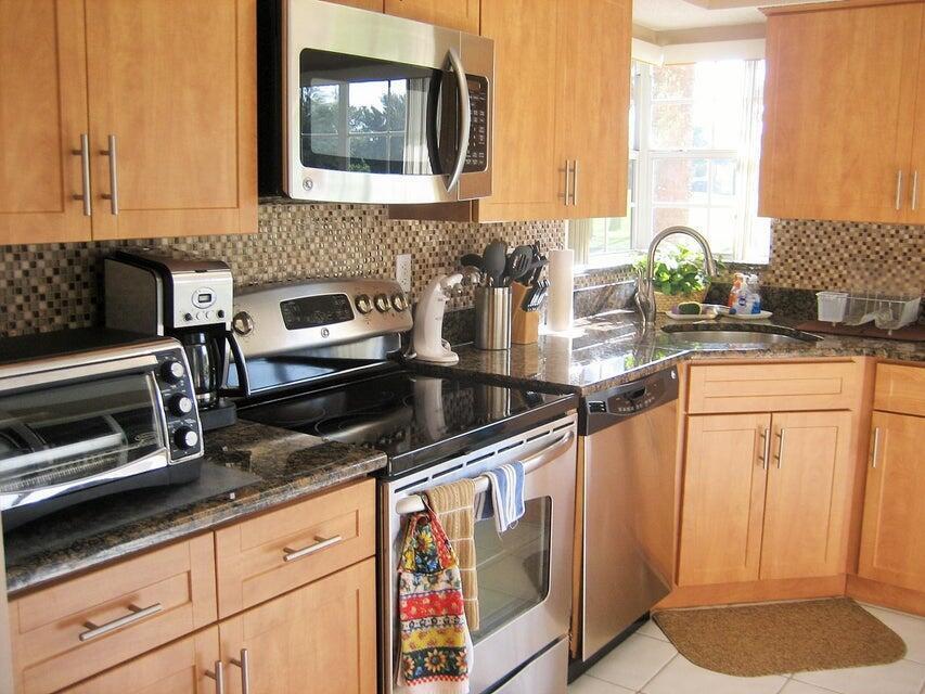 A kitchen with light wood cabinets, stainless steel appliances, and a dark granite countertop — 17256 Boca Club Boulevard # 1401, Boca Raton FL 33487, BOCA RATON, FL