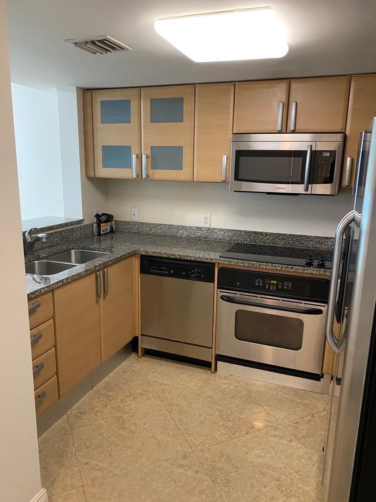 A kitchen with light wood cabinets, stainless steel appliances, and granite countertops — 2101 Brickell Avenue # 504, Miami FL 33129, MIAMI, FL