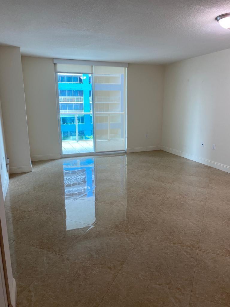 An empty room with beige tile flooring, white walls, and a sliding glass door to a balcony — 2101 Brickell Avenue # 504, Miami FL 33129, MIAMI, FL