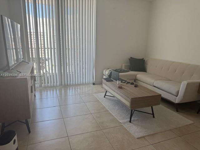 A living room features a beige sofa, a wood coffee table, and a television console — 1250 S Miami Ave # 1607, Miami FL 33130, MIAMI, FL