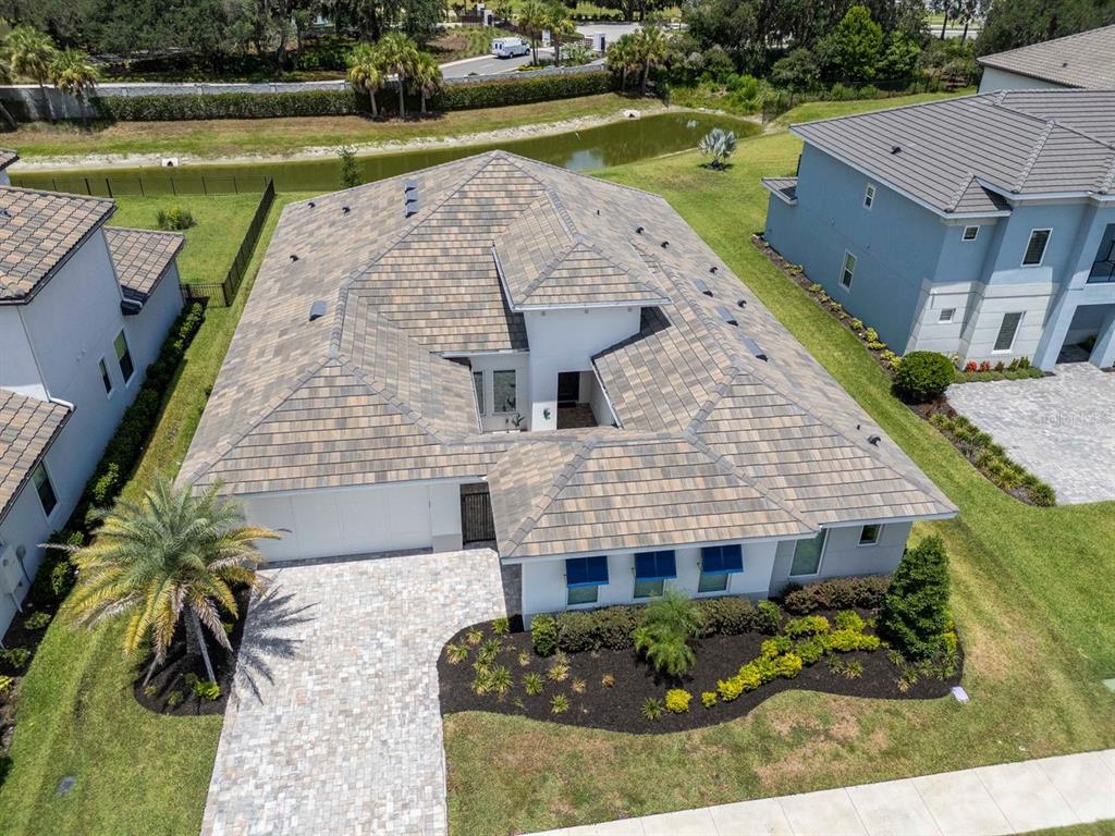 An aerial view of a single-story house with a tiled roof and a paved driveway — 2639 YACHT PLACE, WESLEY CHAPEL, FL