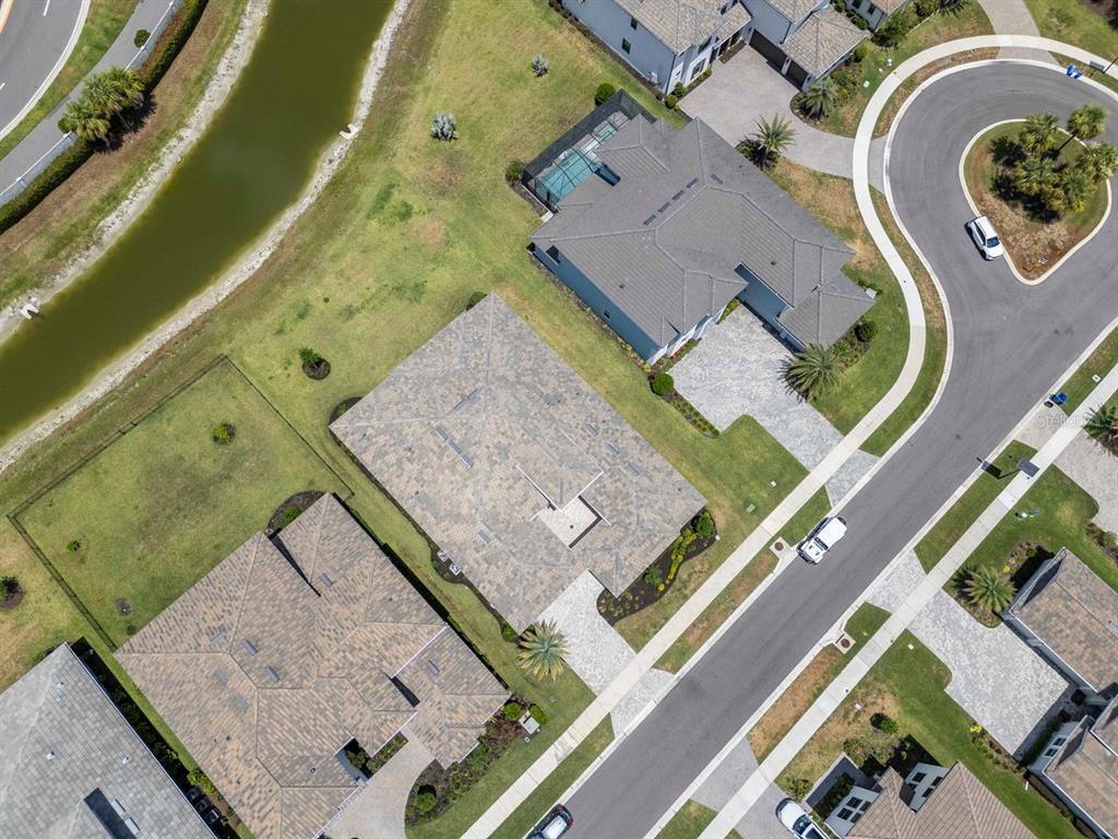 An aerial view shows several suburban houses with paved driveways and lawns near a canal — 2639 YACHT PLACE, WESLEY CHAPEL, FL