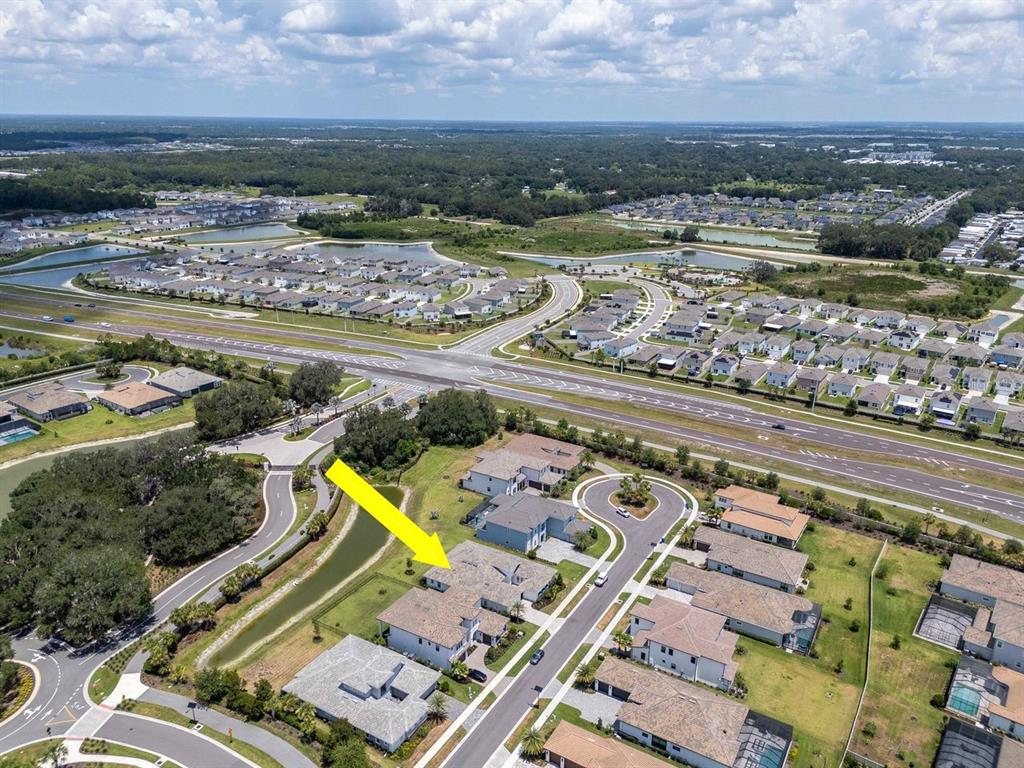 An aerial view shows a residential neighborhood with a yellow arrow pointing to a house — 2639 YACHT PLACE, WESLEY CHAPEL, FL