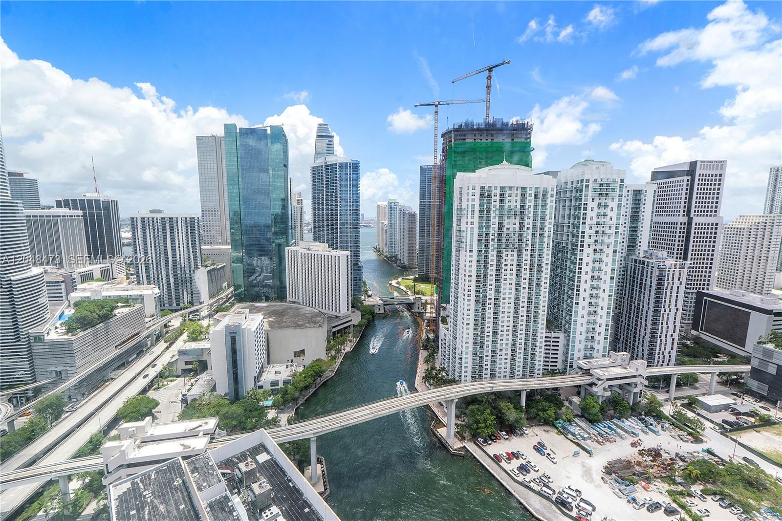 An aerial view of the Miami skyline featuring high-rise buildings, a river, and a monorail track — 350 S Miami Ave # 3702, Miami FL 33130, MIAMI, FL