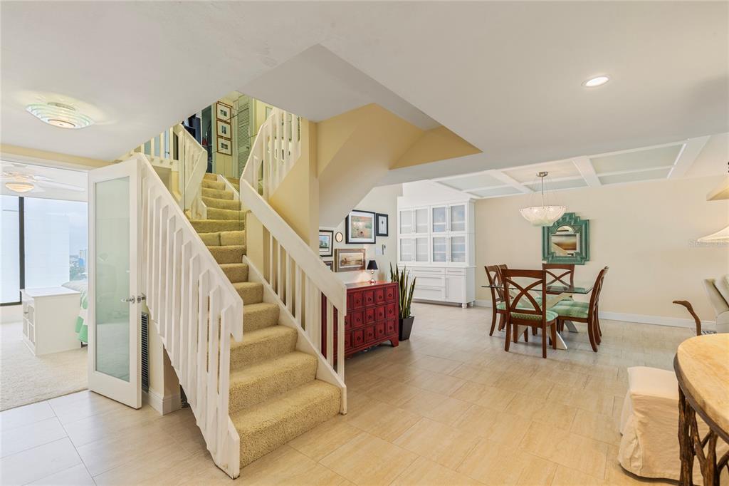 A carpeted staircase leads to an upper level in a room with tile flooring — 440 S GULFVIEW BOULEVARD UNIT 1705, CLEARWATER BEACH, FL