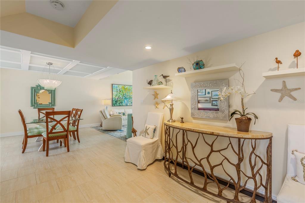 A dining area and entryway feature tile floors, a console table, and coastal-themed wall decor — 440 S GULFVIEW BOULEVARD UNIT 1705, CLEARWATER BEACH, FL