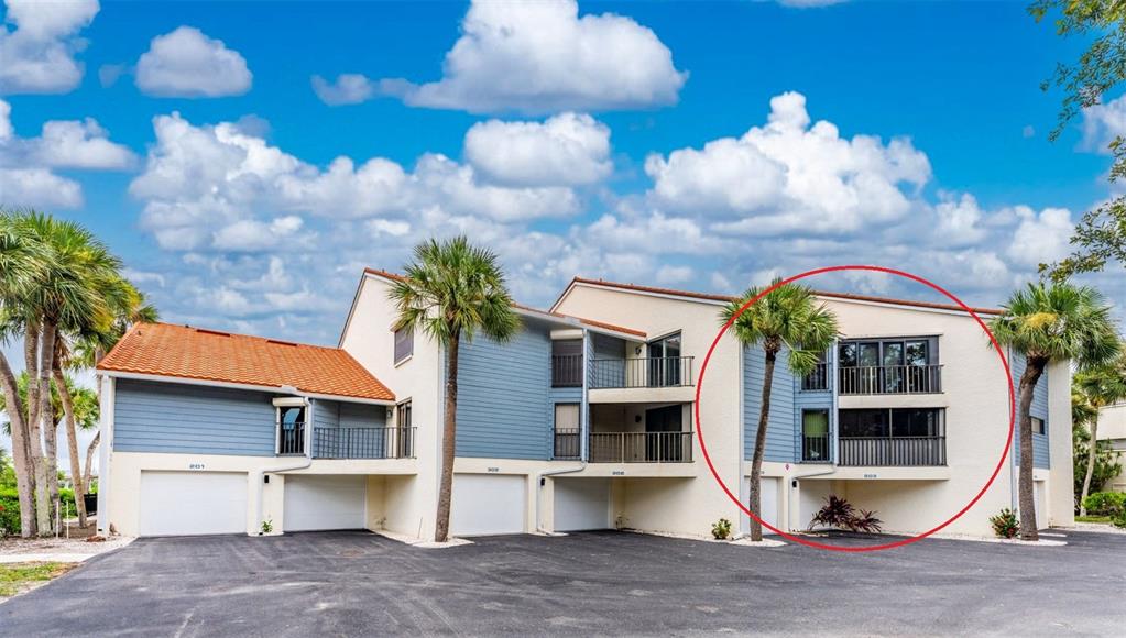 Exterior view of a multi-story apartment building with balconies and a red-circled unit — 1401 BEACH ROAD UNIT 303, ENGLEWOOD, FL