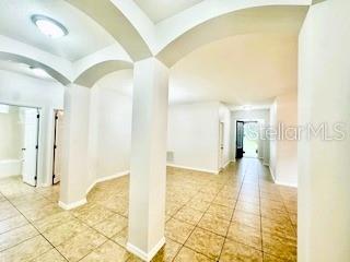 An interior view shows a tiled room with arched architectural details and white columns — 8107 NORTHLAKE PARKWAY, ORLANDO, FL