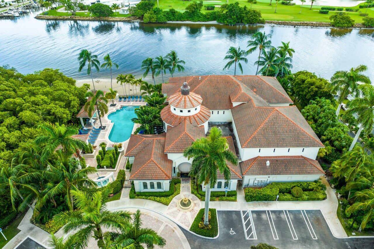 An aerial view shows a large waterfront building with a tiled roof, pool, and parking — 1302 Tuscany Way, Boynton Beach FL 33435, BOYNTON BEACH, FL