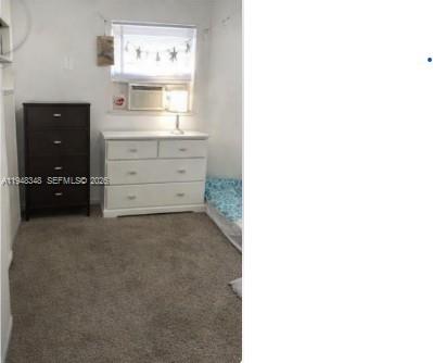 A bedroom features a dark dresser, a white dresser, and a window with an air conditioner — 1489 W 34th St, Riviera Beach FL 33404, RIVIERA BEACH, FL