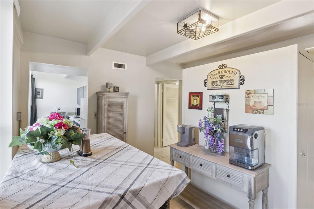 A dining area features a plaid-covered table, a coffee station, and wall-mounted coffee-themed decor — 3037 CLUB CIR, LAKESHORE, FL