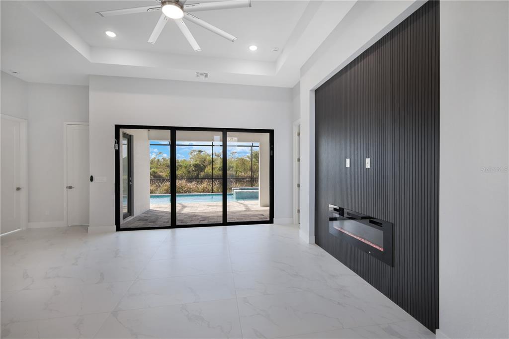 A living room features white marble-look tile floors, a black slatted accent wall, and sliding doors — 10123 BOYLSTON STREET, PORT CHARLOTTE, FL