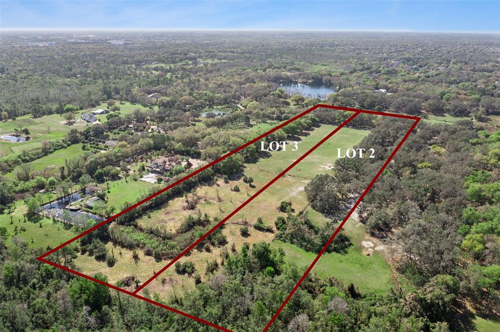 An aerial view shows two adjacent rectangular plots of land outlined in red — LOT 2 OAK HOLLOW, OVIEDO, FL