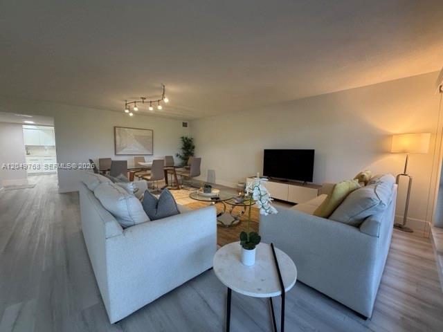 A living room features two light-colored sofas, a dining area, and a television — LAUDERDALE BY THE SEA, FL