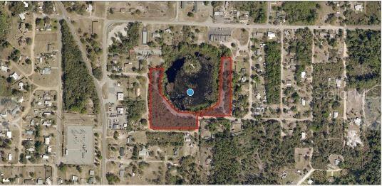 An aerial view shows a U-shaped parcel of land outlined in red surrounding a pond — WESTERN AVENUE, LEESBURG, FL