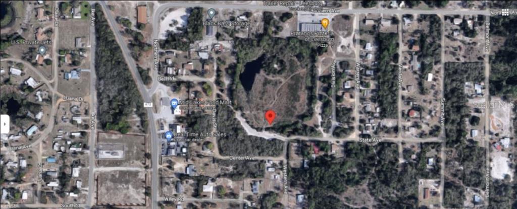 This is an aerial map view showing a vacant lot marked with a red pin — WESTERN AVENUE, LEESBURG, FL