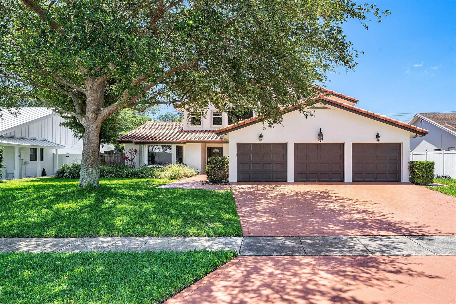 A three-car garage house with a red tile roof and a large tree in front — 1560 SW 17th Street, Boca Raton FL 33486, BOCA RATON, FL