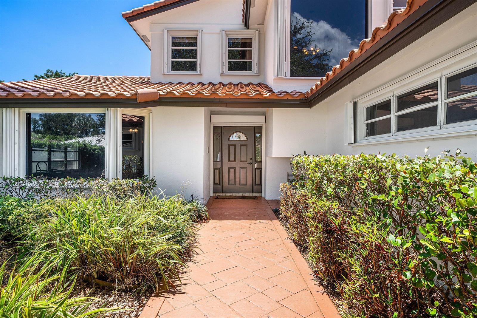 A paved walkway leads to the front entrance of a two-story house with tiled roofing — 1560 SW 17th Street, Boca Raton FL 33486, BOCA RATON, FL