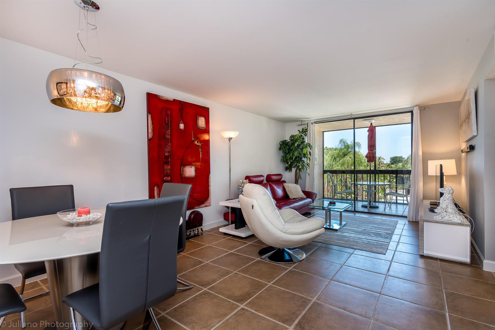 A living and dining area features tile floors, a red sofa, and a glass balcony door — 2255 Lindell Boulevard # 4306, Delray Beach FL 33444, DELRAY BEACH, FL